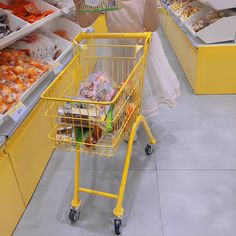 a yellow shopping cart in a store filled with food