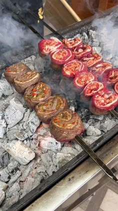 the grill is full of meat and vegetables cooking on it's own charcoals