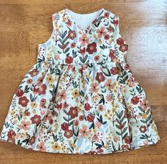 This Preemie dress will fit a child 3-1/2 to 4-1/2 pounds.   The dress is made with a quality floral print cotton fabric, warm Autumn hues. The bodice is lined and the skirt is gathered at the waist.  Topstitching around the neckline and armholes.  Dress opens/closes in front with two KAM Snaps.   This style dress wraps around the body like a blanket, allowing for easy dressing:  no pulling garments over the head.  Adaptive style clothing also allows access for any medically supported equipment.    The dress can also open at the shoulders with KAM Snaps.  Please request this option at checkout. Child Height 16-17" Chest:  10-11" 3-1/2 to 4-1/2 pounds Dress Length: 9" Doll not included.   Not suitable for sleepwear.  Please supervise your child while wearing the dress. Washing instructions: Adaptive Clothing, Warm Autumn, Simple Dresses, Baby Girl Clothes, Dress Length, Wrap Dress, Baby Clothes, Girls Dresses, Cotton Fabric