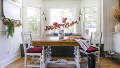 a dining room table with two chairs and a potted plant in the center on top