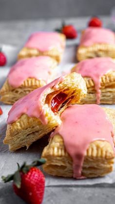 strawberry hand pies with pink icing and strawberries on the side, ready to be eaten