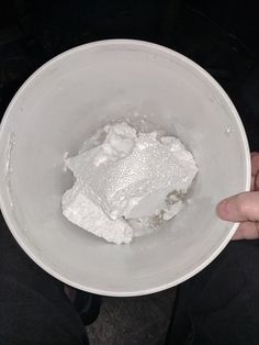 a person holding a bowl filled with white powder