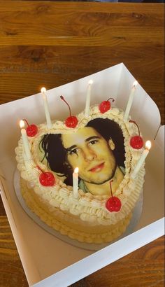 there is a cake with candles on it and a picture of a man in the middle