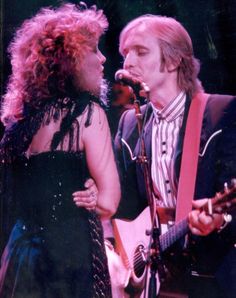 a man and woman singing into microphones on stage