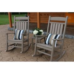 two wooden rocking chairs with striped pillows on them