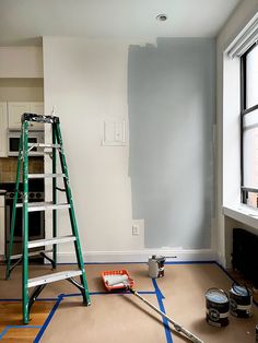 a ladder and paint rollers in a room