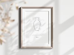 a framed drawing of a vase is hanging on the wall next to a dried plant