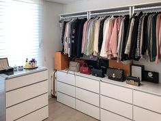 an organized closet with clothes and handbags on the shelves, next to a dresser