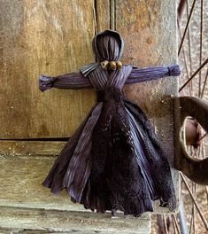 a doll is hanging on the side of a wooden door