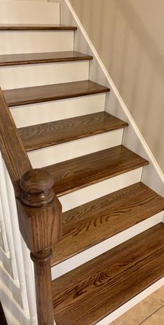 the stairs are made of wood and have white handrails