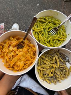 three bowls filled with different types of pasta and other foods on top of a table