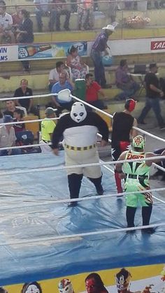 two people in costumes standing on a wrestling ring