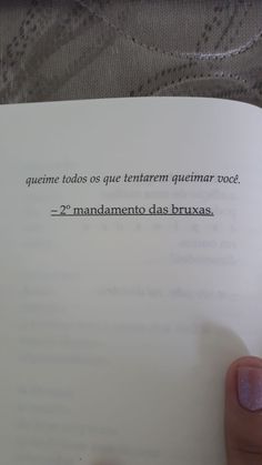 a person holding up a book in their left hand with spanish writing on the page