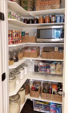 an organized pantry with lots of food in baskets and containers on the bottom shelf, along with other items