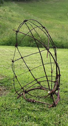 a metal sculpture sitting on top of a lush green field