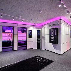 an empty room with purple lighting on the ceiling and white cabinets in the corner,