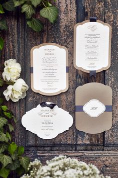 the wedding stationery is laid out with flowers and greenery in front of it