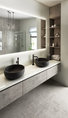 a bathroom with two sinks and a large mirror on the wall above it's counter