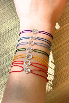 A rainbow collection of woven friendship bracelets, featuring a 925 Sterling Silver Chakra symbol. Throat Chakra Symbol, Silver Friendship Bracelets, Chakra Symbols, We Are Love, Chakra Bracelet, Throat Chakra