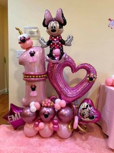 a minnie mouse balloon sculpture with balloons and heliums on the floor next to it