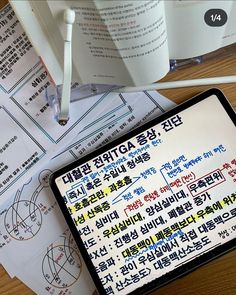 there is a cell phone on the table next to some books and papers that are written in different languages