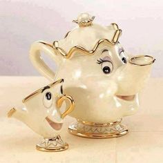 two teapots with faces on them sitting next to each other