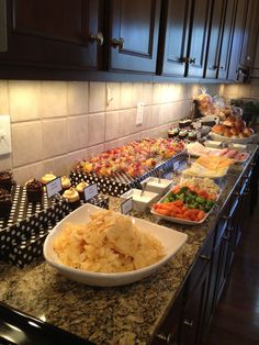 a buffet with many different types of food on the counter and in bowls next to each other