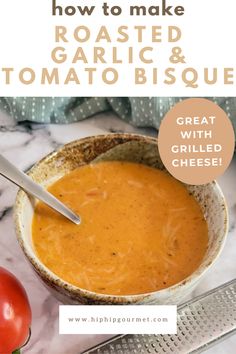 bowl of tomato bisque with a spoon in it next to another bowl of soup, a mandolin, and a fresh tomato