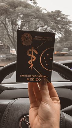 a person holding up a card in their car