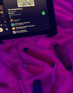 a tablet with some lipstick on it and several other items in front of the screen