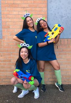 three girls are dressed up in costumes and holding nerfle toys while posing for the camera