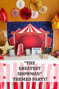 the greatest showman themed party with red, white and gold decorations on display in front of a circus tent