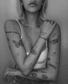 a black and white photo of a woman with tattoos on her arms