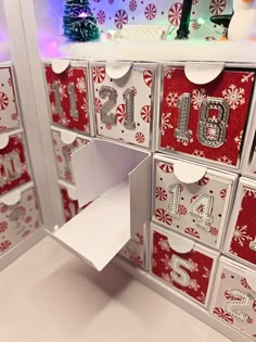 an open drawer with christmas decorations on the top and bottom, in front of a wall