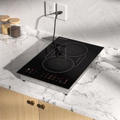 a black stove top sitting on top of a kitchen counter