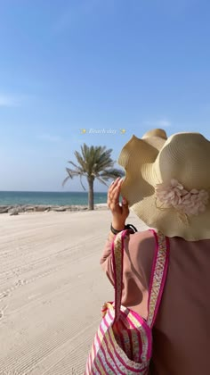 a woman wearing a large hat on the beach