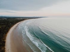 an aerial view of the beach and ocean at sunset or sunrise, taken from above