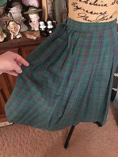 "Vintage 1970's plaid Cotton blend skirt. The main color is green with subtle Yellow, Blueish Purple Bittersweet Orange. Has a one button closure on the left side. The skirt is to small for my dressform, so it is clipped on the button side. *MORE INFORMATION BELOW* CONDITION: I note on the left side by the button, the skirt opening could use a few stitches to make the opening smaller (SEE PIX). There is supposed to be an opening in that area to be able to get the skirt on. Only closes with the o Retro Green Pleated Bottoms, Vintage Green Full Skirt Bottoms, Retro Green Pleated Skirt, Vintage Green Full Skirt, Vintage Plaid Summer Skirt, 1940s Plaid Skirt, 1950s Plaid Skirt, Blueish Purple, Retro Plaid Lined Skirt