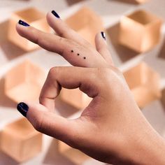 a woman's hand with black nail polish holding up her fingers