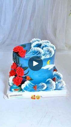 a blue cake with red roses on it and a video player in front of it