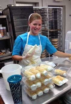 a woman in an apron is making cupcakes