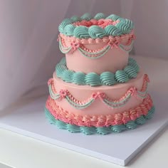 three tiered cake with pink and blue frosting