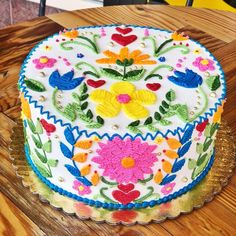 a decorated cake sitting on top of a wooden table