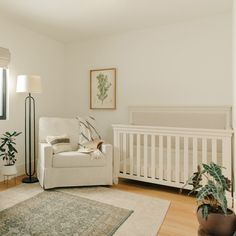 a baby's room with a crib, chair and rug