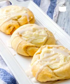 three rolls with icing on a white plate