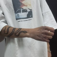 a person wearing a white shirt with tattoos on their arm