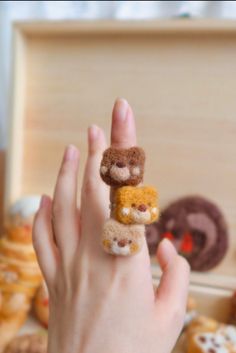 a person's hand with a ring made out of tiny stuffed animals on it