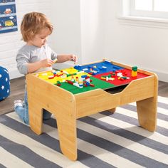 a young child playing with a wooden toy table