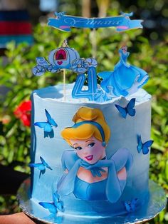 there is a blue cake with princess on it