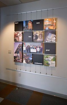 a group of people standing next to each other in front of a wall with pictures on it